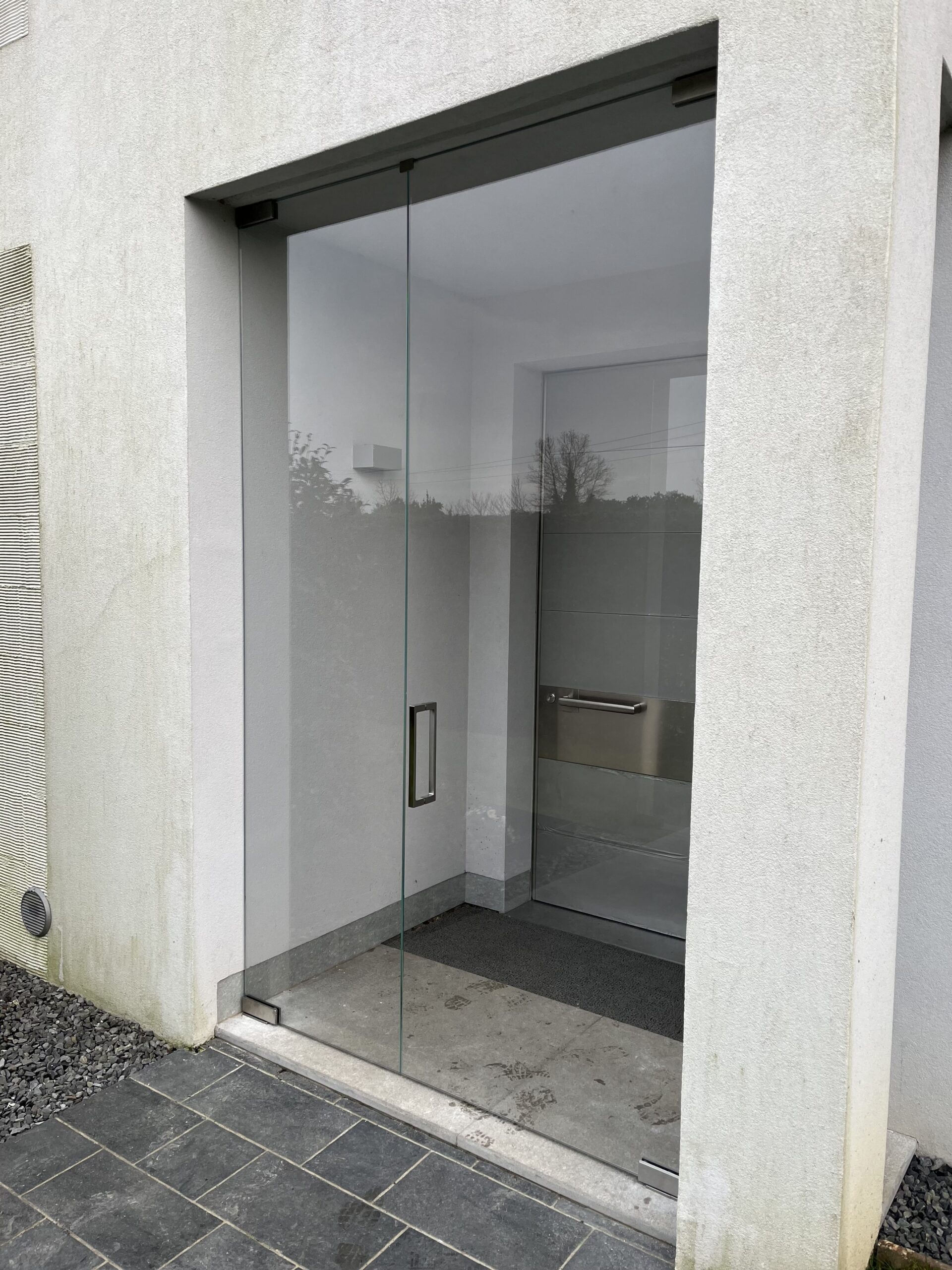 Porta in vetro da esterno con cerniere oleodinamiche a chiusura automatica