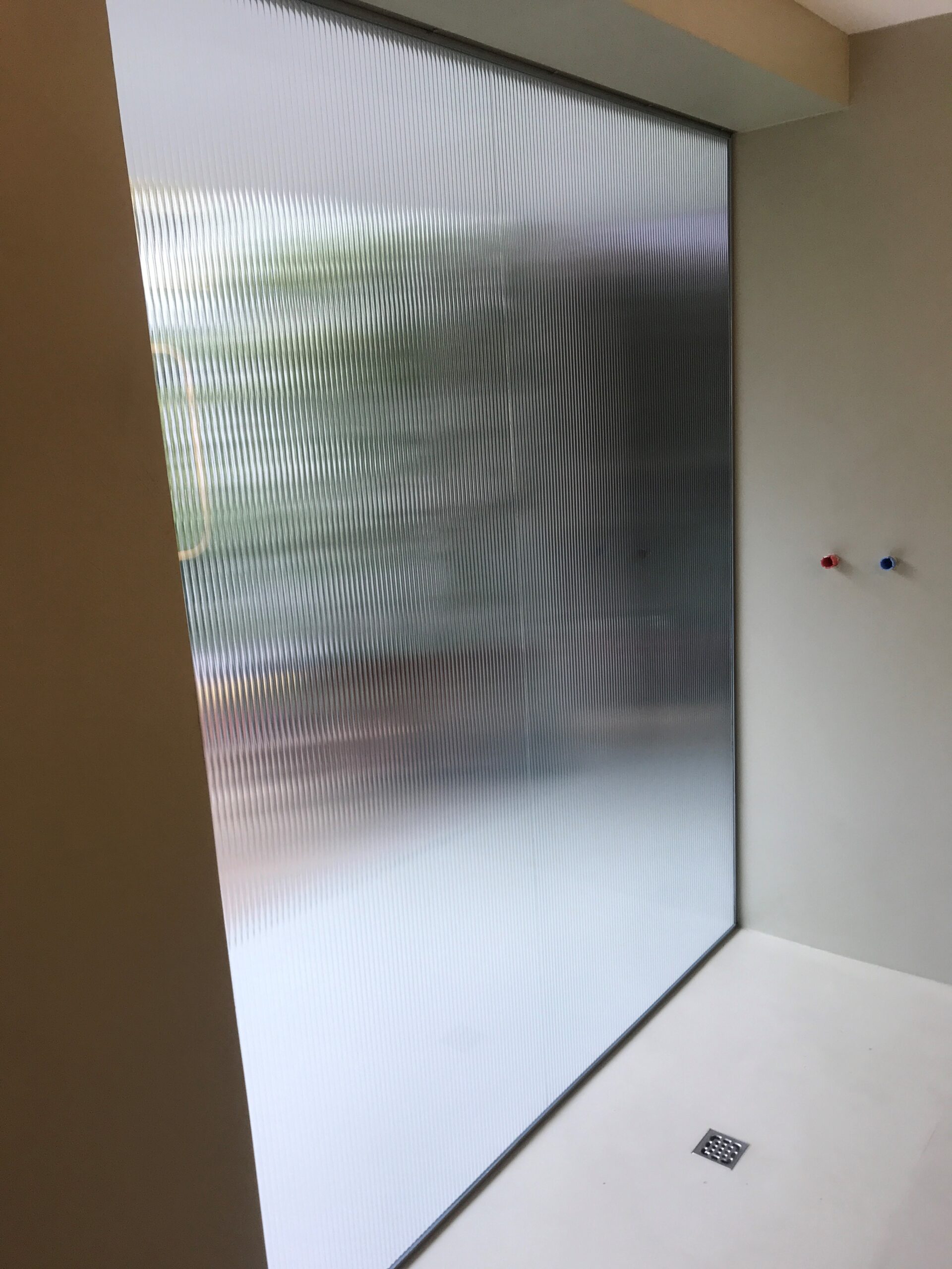 Divisorio in vetro opaco per una privacy elegante in un edificio moderno, Veneto.