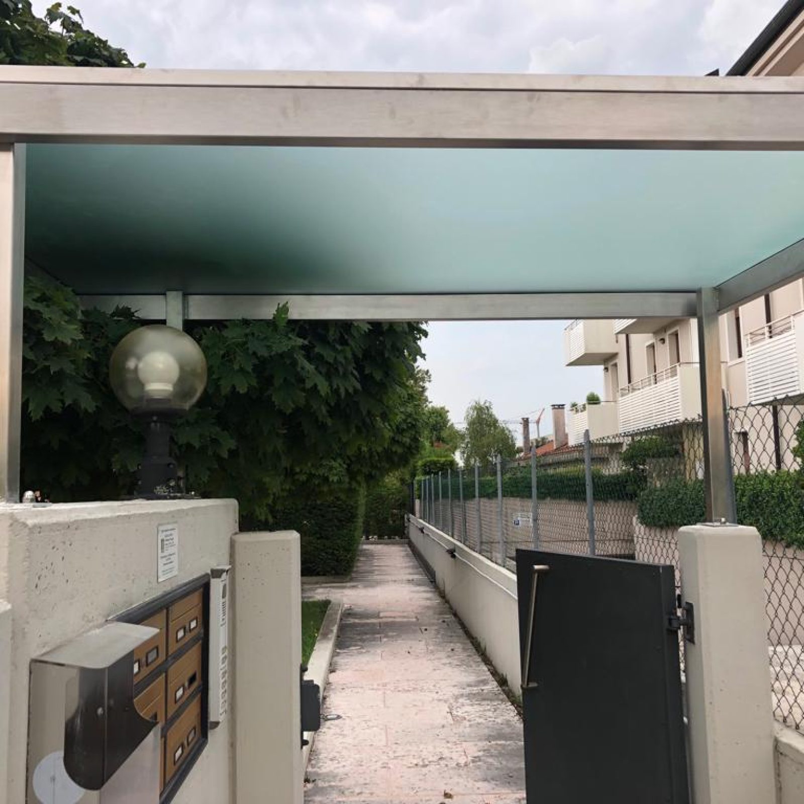Pensilina in vetro opaco per cancelletto di ingresso in Veneto.