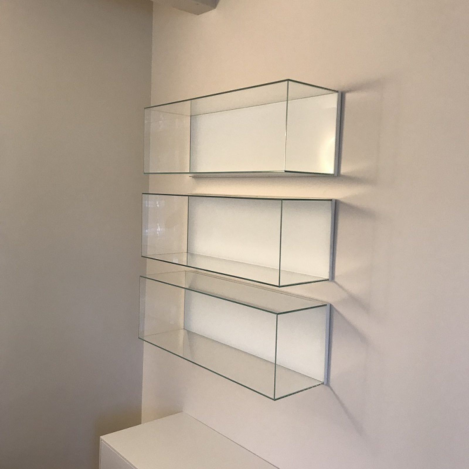 Mensole in vetro sospese su muro dal design moderno a Treviso