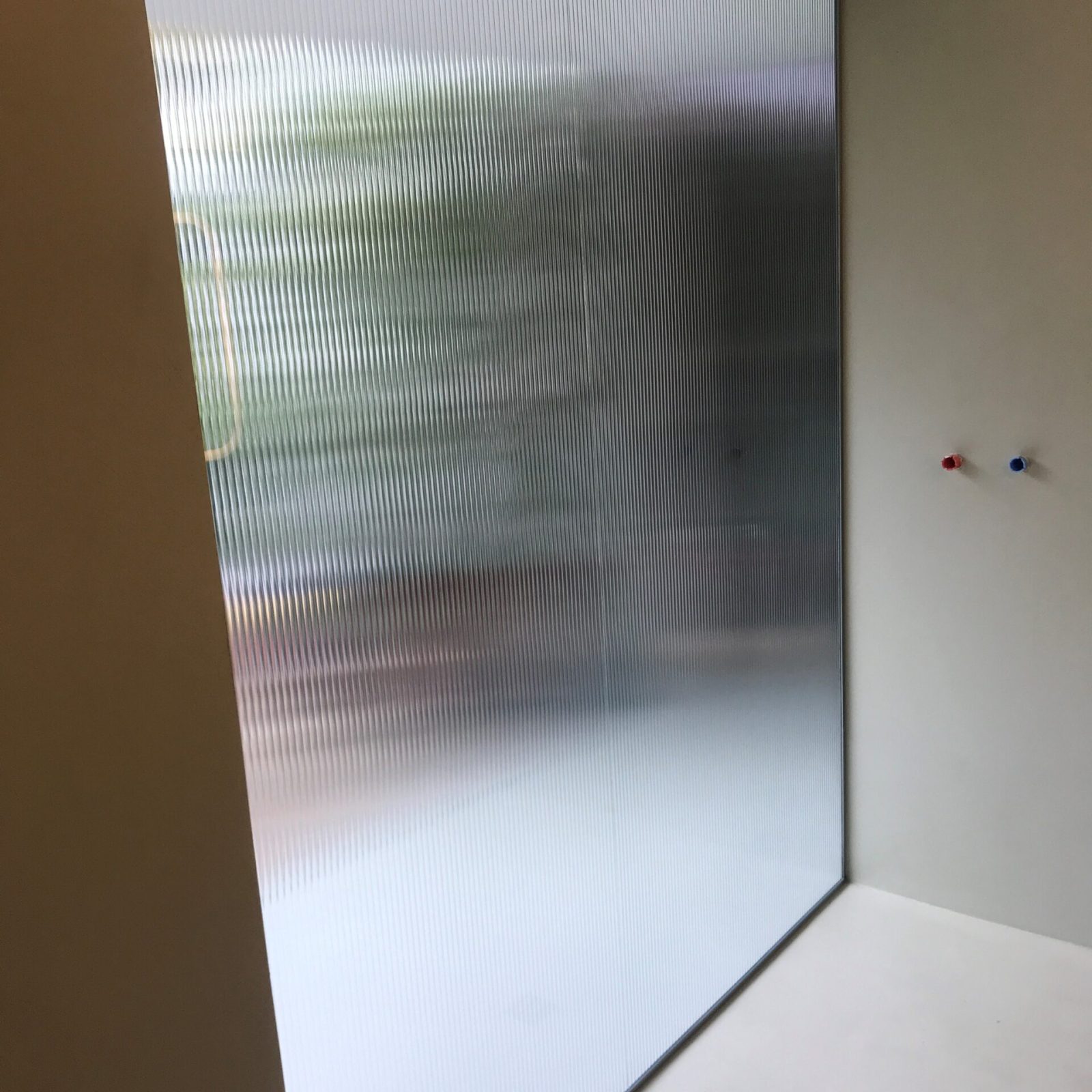Divisorio in vetro opaco per una privacy elegante in un edificio moderno, Veneto.